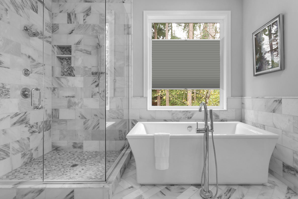 Bathroom with bathtub and shower in new luxury home with all gla